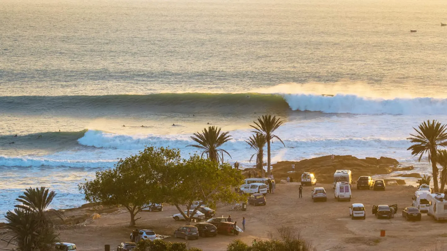 Waves breaking along the point near Taghazout, palms in the foreground